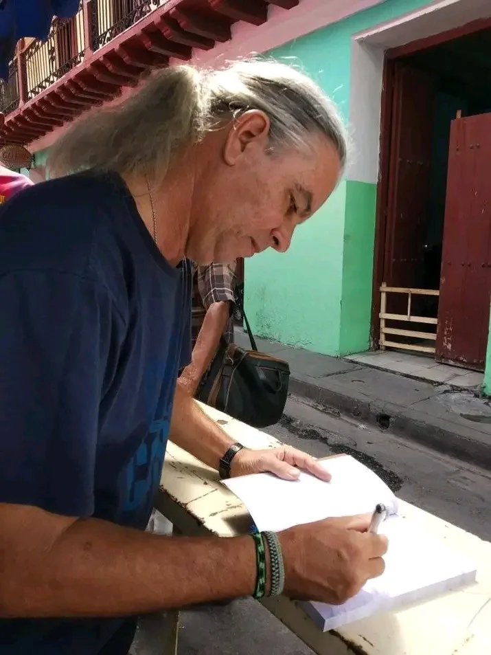 Firma de un ejemplar apoyado en la mano, en plena calle
