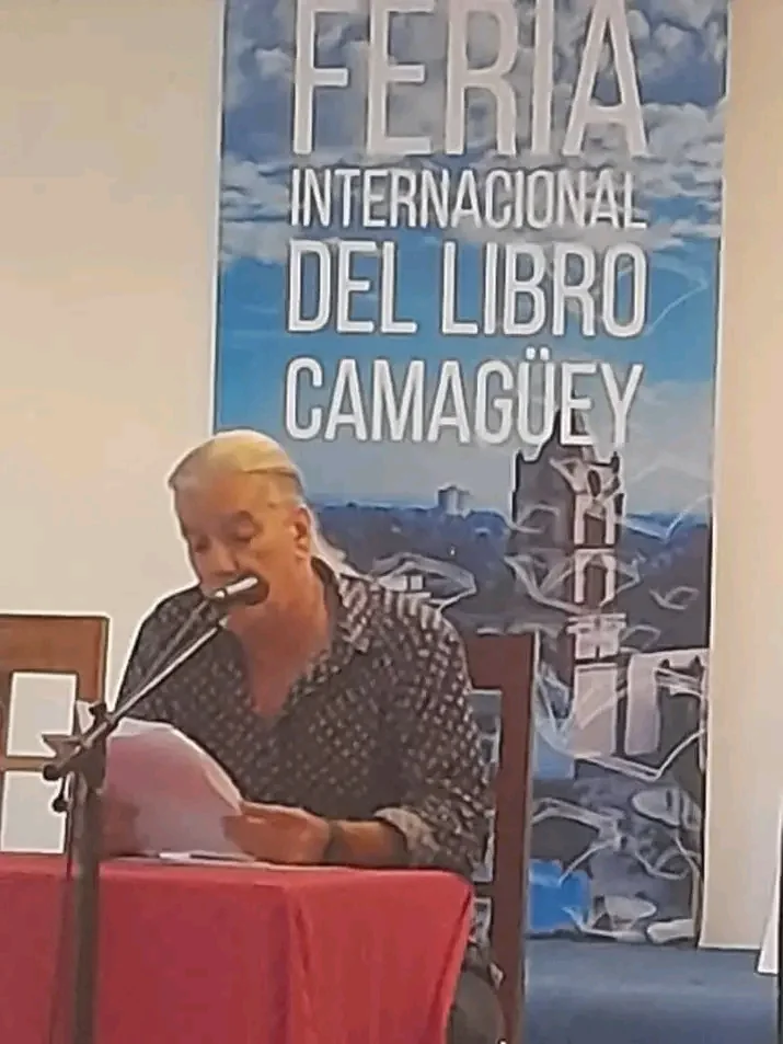Lectura de poemas ante el cartel de la Feria del Libro de Camagüey