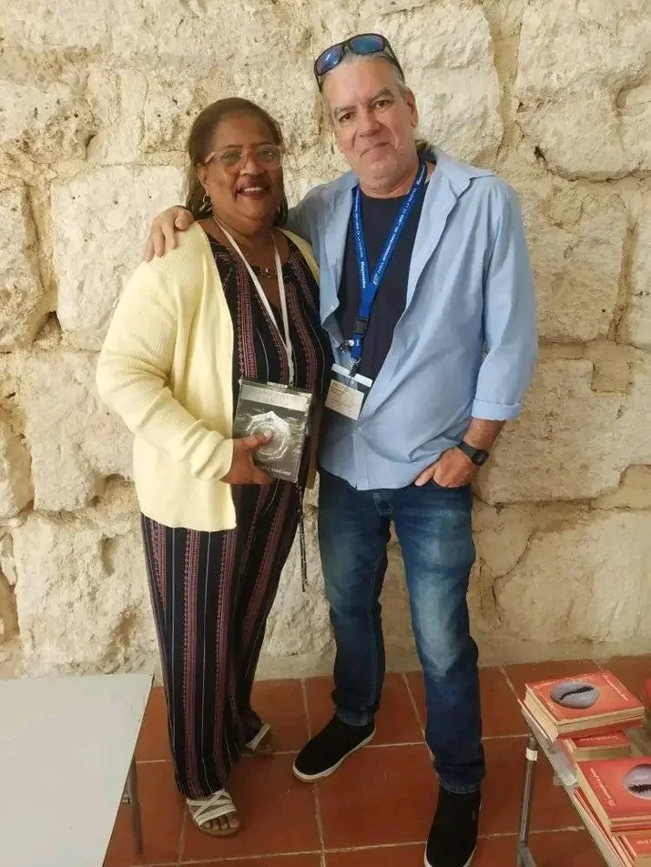 Dos personas sosteniendo ejemplares del libro en una feria