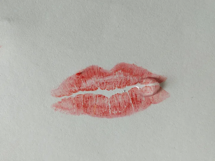 L'empreinte de deux lèvres au rouge à lèvres, laissée sur du papier blanc