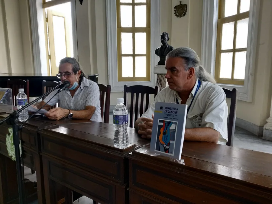 Two participants at a launch table, one holding the book