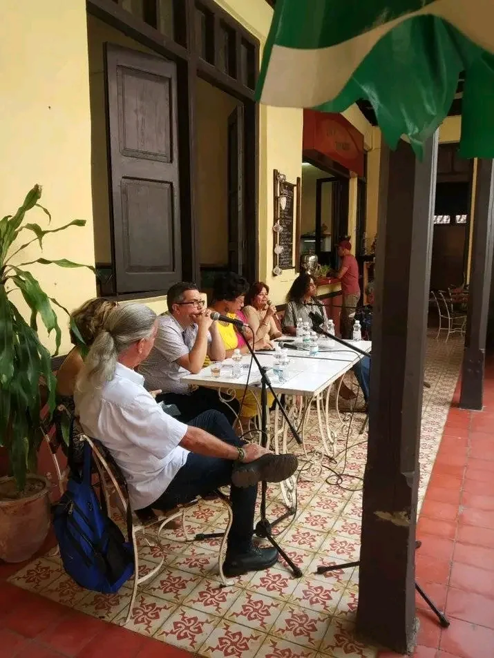 Launch of the book in a colonnaded courtyard, before a seated audience