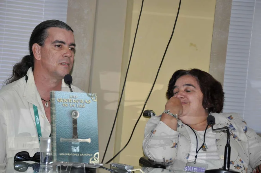Two people at the launch table with the book between them